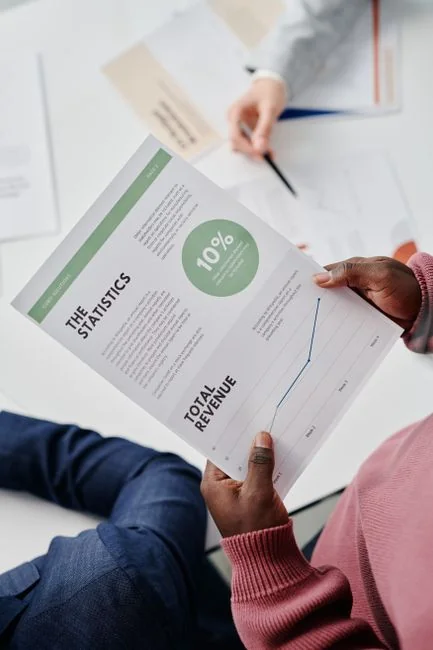 Focused business analysis with charts and graphs on a laptop in a modern office setting.